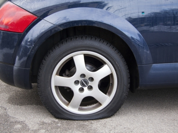 Driving to the store, you see your co-worker stranded on the side of the road with a flat tire. What do you do?